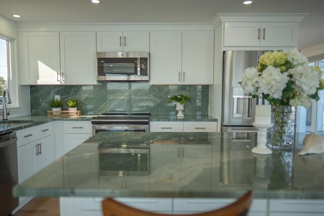kitchen featuring a sink, white cabinets, stainless steel appliances, and tasteful backsplash