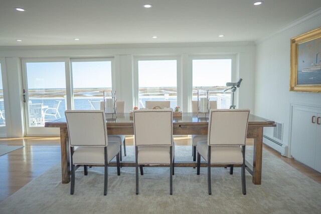 dining space featuring crown molding, recessed lighting, baseboard heating, and light wood-style floors