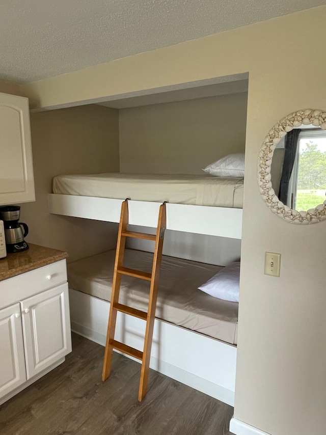 unfurnished bedroom with dark wood-type flooring and a textured ceiling