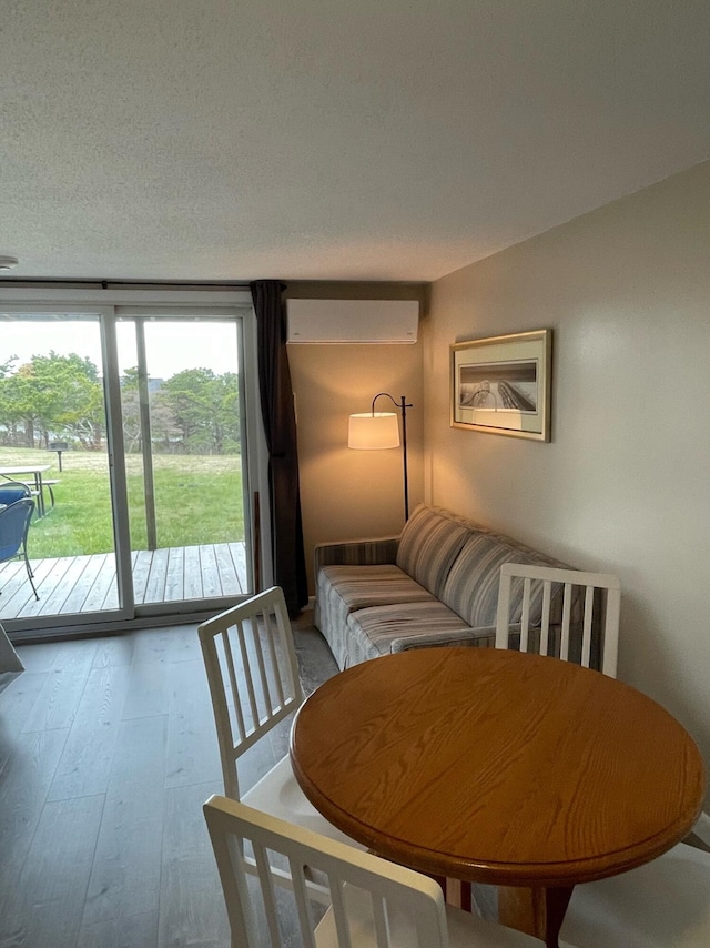 132 Shore Rd Unit 3, Truro, MA 02666 - dining room with a wall mounted air conditioner, hardwood / wood-style flooring, and a textured ceiling