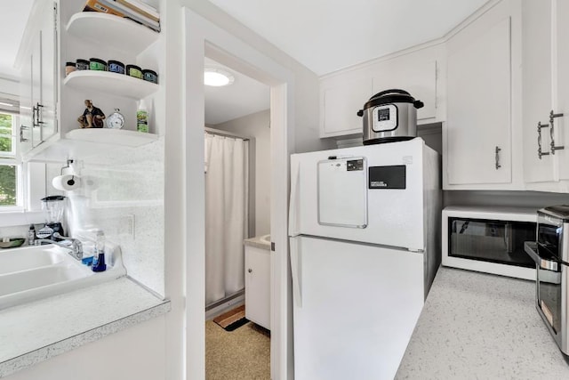 kitchen featuring white cabinetry and white refrigerator
