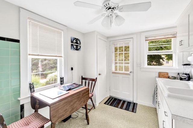 home office with sink, light colored carpet, and ceiling fan