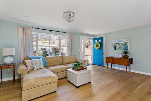 living area with light wood-type flooring and baseboards