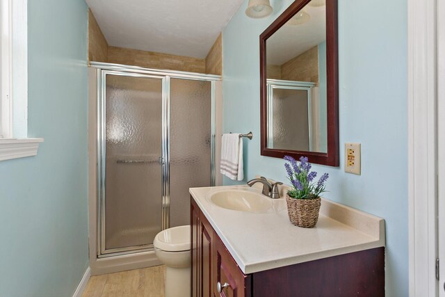 full bathroom with vanity, a shower stall, toilet, and wood finished floors