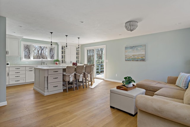 living area with light wood-style floors and baseboards