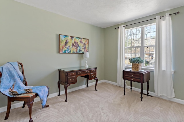 sitting room with baseboards and light carpet