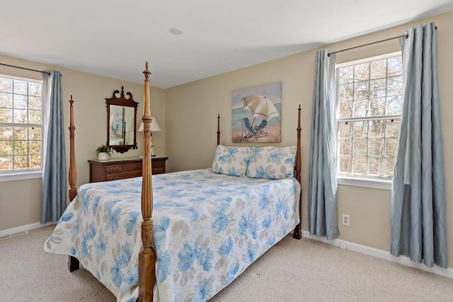 carpeted bedroom with visible vents, multiple windows, and baseboards