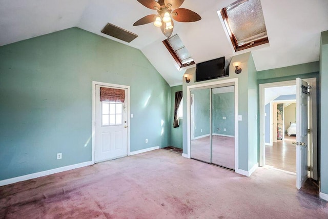 interior space featuring carpet floors, baseboards, vaulted ceiling, and a ceiling fan