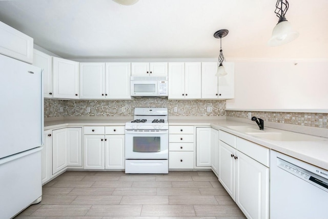 kitchen featuring white appliances, decorative backsplash, hanging light fixtures, light countertops, and white cabinetry