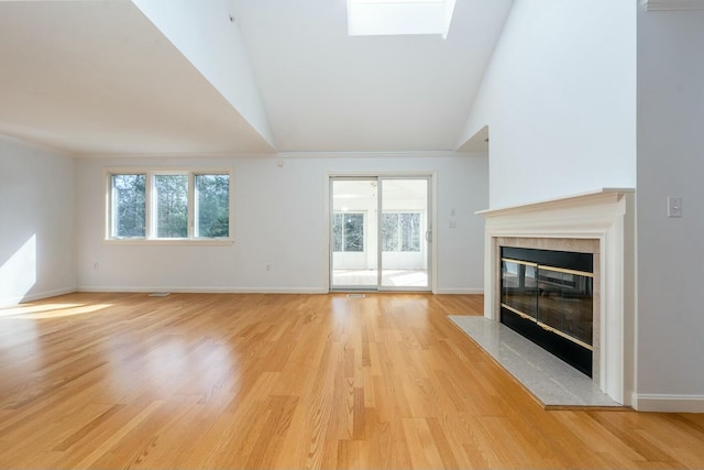 unfurnished living room featuring plenty of natural light, light wood-type flooring, and a fireplace