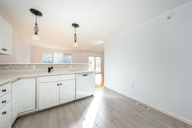 kitchen featuring visible vents, white cabinets, white dishwasher, light wood-style floors, and a sink