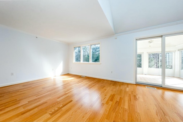 unfurnished room featuring baseboards, light wood-style floors, visible vents, and crown molding