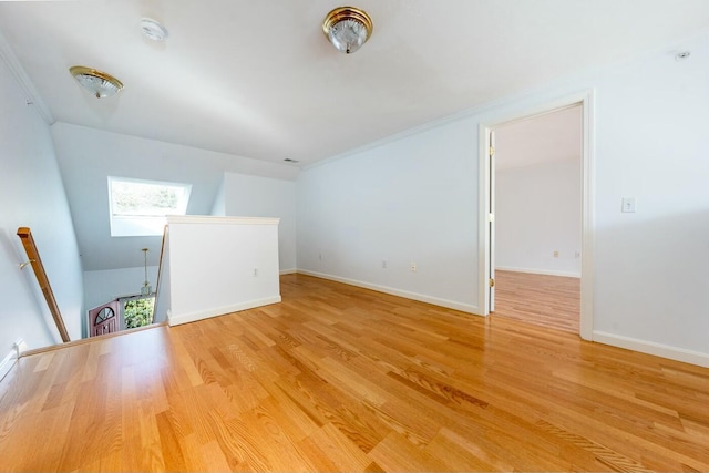 unfurnished room with light wood-type flooring, baseboards, and ornamental molding