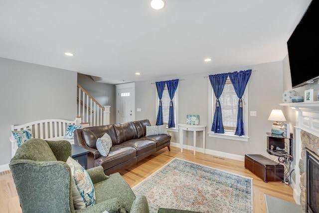 living room with recessed lighting, stairway, wood finished floors, a premium fireplace, and baseboards