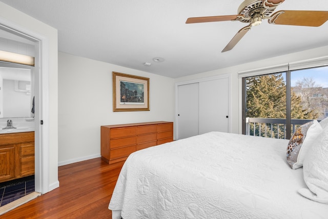 bedroom with a closet, sink, access to outside, ceiling fan, and dark hardwood / wood-style floors