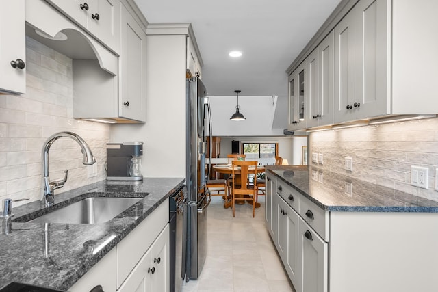 kitchen featuring decorative light fixtures, sink, gray cabinets, and dark stone counters