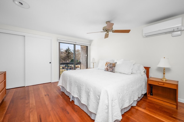 bedroom with wood-type flooring, access to exterior, a wall mounted AC, and ceiling fan