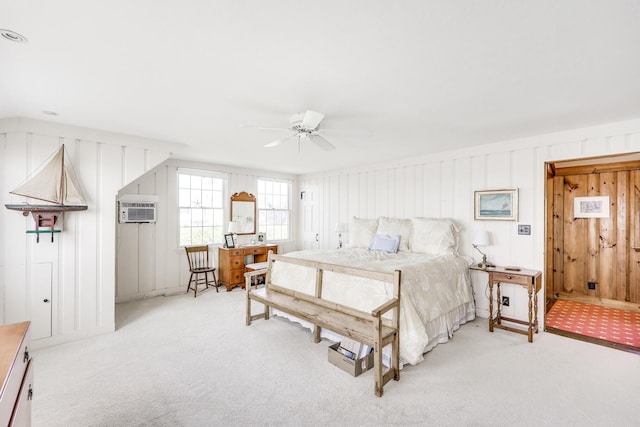 bedroom with light carpet, ceiling fan, and a wall mounted AC