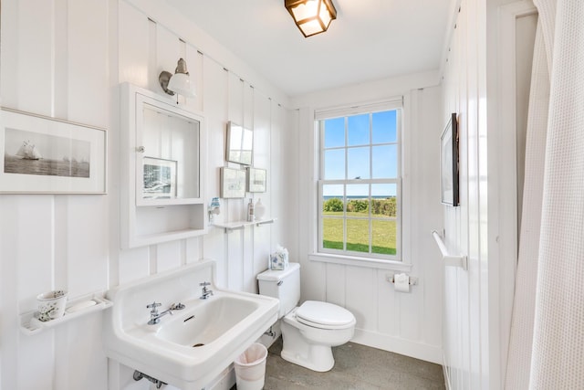 full bath with a sink, toilet, and baseboards
