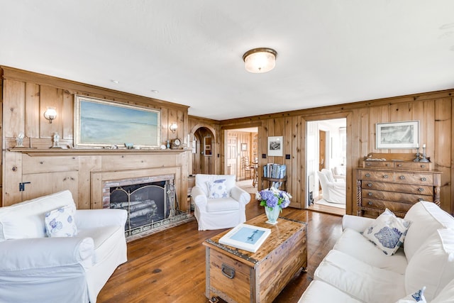 living area with hardwood / wood-style floors, a fireplace, and wooden walls