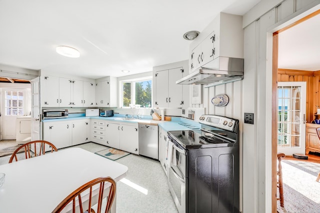 kitchen featuring washer / clothes dryer, light countertops, appliances with stainless steel finishes, white cabinets, and under cabinet range hood