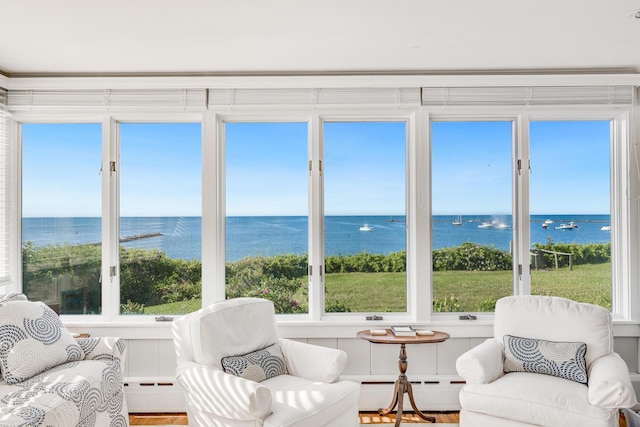 sunroom featuring a baseboard radiator and a water view