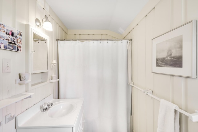 bathroom featuring lofted ceiling, curtained shower, and vanity