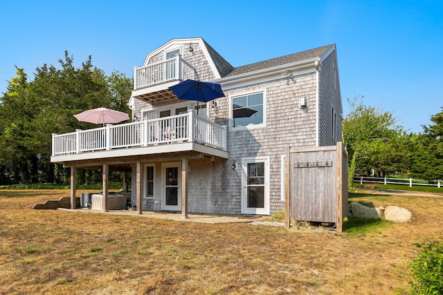 63 Briar Spring Rd, Orleans, MA 02653 - rear view of house featuring a wooden deck, a lawn, a hot tub, and a shingled roof