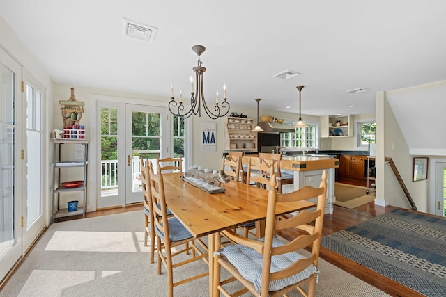 63 Briar Spring Rd, Orleans, MA 02653 - dining space featuring french doors, a chandelier, and wood finished floors