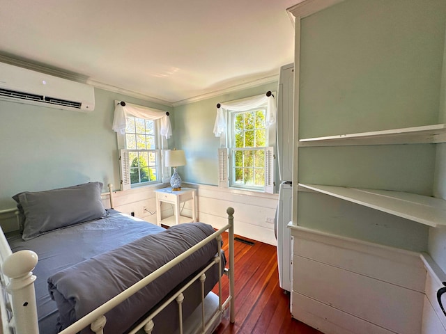 bedroom featuring dark wood-style floors, an AC wall unit, wainscoting, and multiple windows