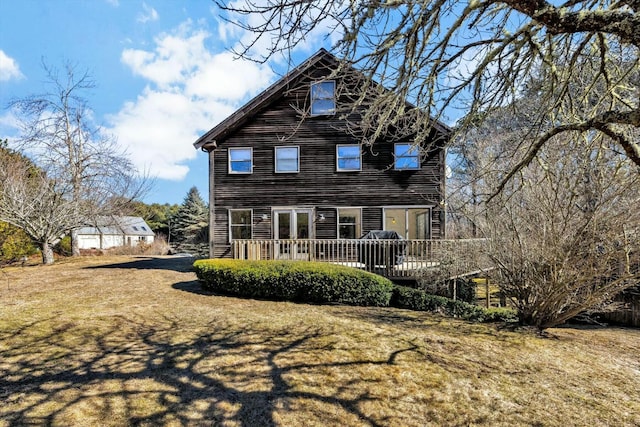 rear view of property featuring a lawn and a wooden deck