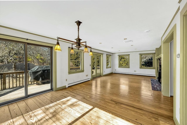 interior space with baseboard heating, plenty of natural light, and visible vents