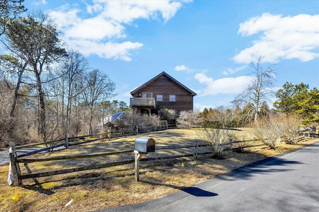 rustic home featuring fence