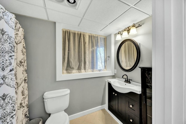 full bathroom with curtained shower, toilet, a paneled ceiling, vanity, and baseboards