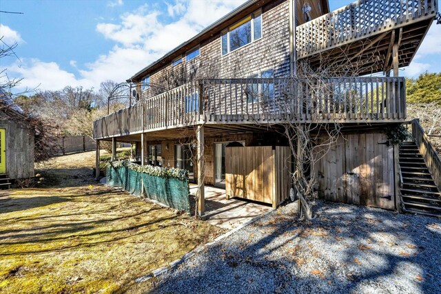 rear view of property with stairs and a deck