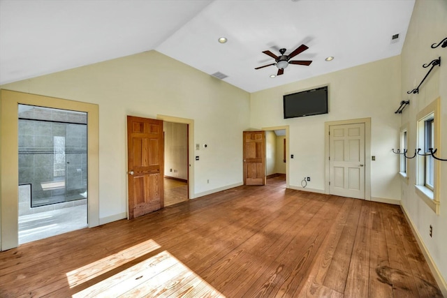 unfurnished bedroom featuring high vaulted ceiling, hardwood / wood-style floors, visible vents, and baseboards