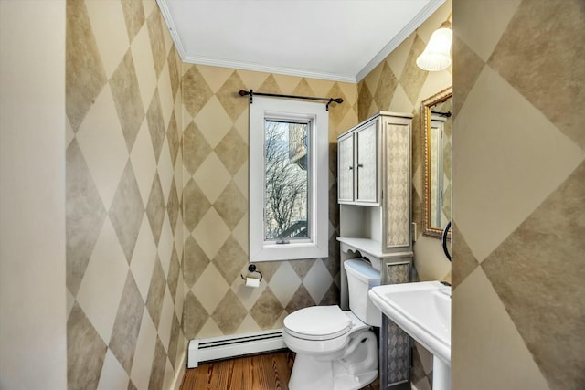 bathroom featuring toilet, wood finished floors, crown molding, a baseboard heating unit, and a sink