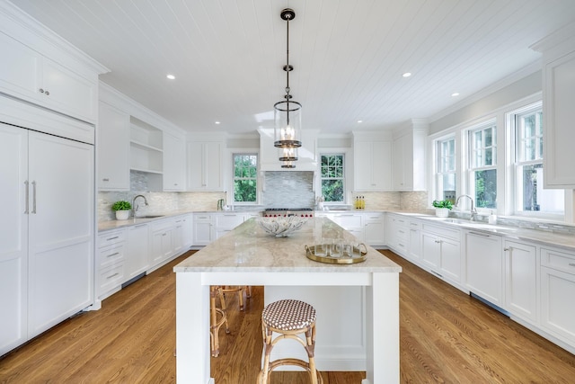 71 Towhee Ln, Orleans, MA 02653 - kitchen with a kitchen island, open shelves, a sink, and light wood-type flooring