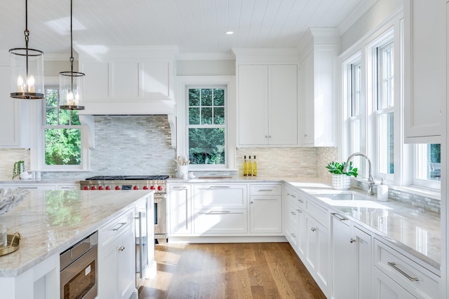 71 Towhee Ln, Orleans, MA 02653 - kitchen with crown molding, appliances with stainless steel finishes, a sink, light wood finished floors, and white cabinetry
