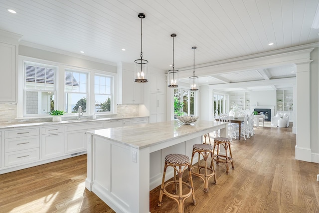 71 Towhee Ln, Orleans, MA 02653 - kitchen with recessed lighting, a sink, backsplash, and a kitchen island