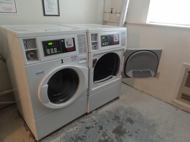 clothes washing area with washer and clothes dryer