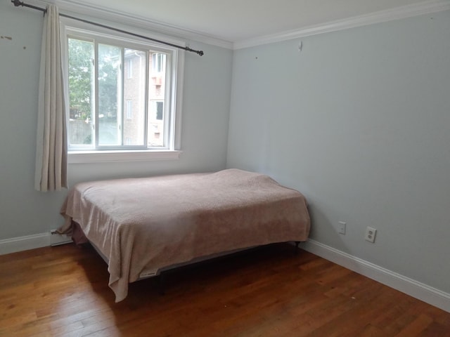 bedroom featuring crown molding and dark wood-type flooring