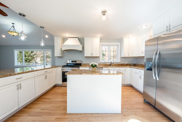 kitchen with a center island, pendant lighting, custom exhaust hood, stainless steel appliances, and white cabinetry