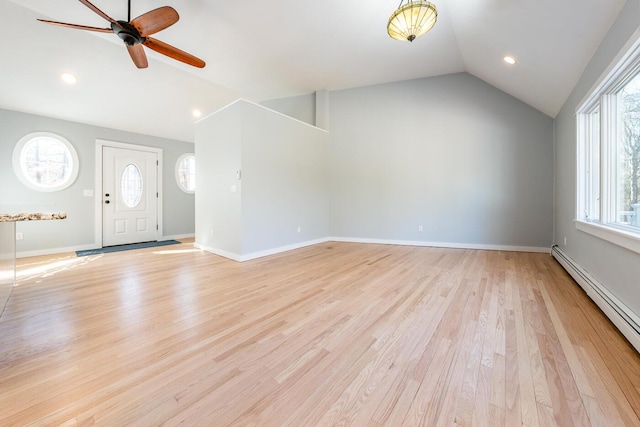 interior space featuring lofted ceiling, light wood-style floors, a baseboard radiator, and baseboards