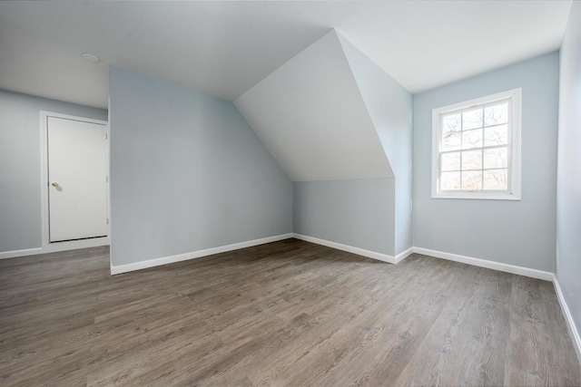 bonus room with baseboards, vaulted ceiling, and wood finished floors