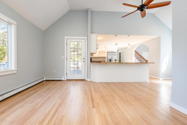 unfurnished living room featuring ceiling fan, light wood finished floors, a baseboard radiator, and baseboards