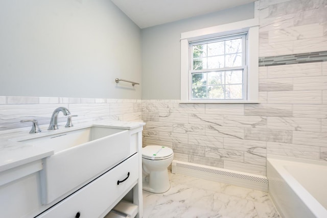 bathroom featuring toilet, vanity, tile walls, marble finish floor, and a tub