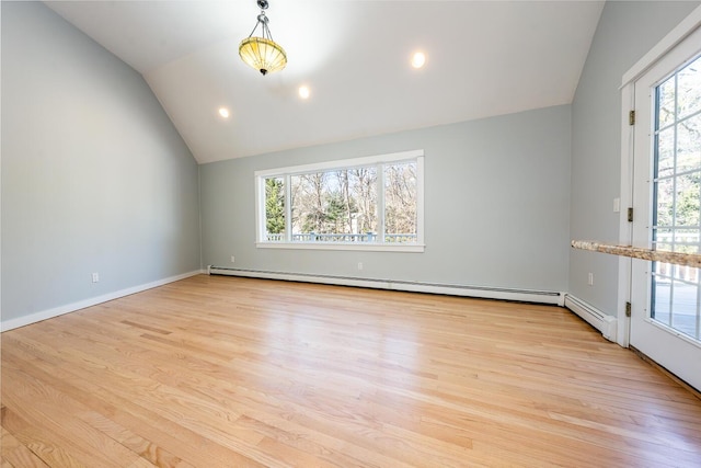 empty room featuring light wood-type flooring, a wealth of natural light, vaulted ceiling, and baseboard heating