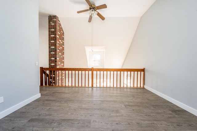 empty room with ceiling fan, dark wood-type flooring, lofted ceiling, and baseboards