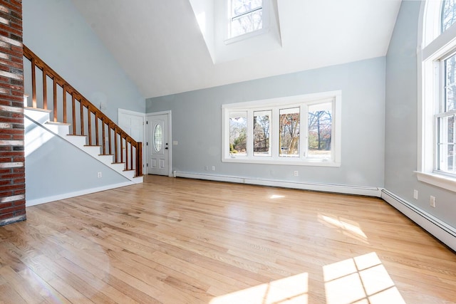 unfurnished living room with stairs, high vaulted ceiling, a baseboard radiator, and plenty of natural light